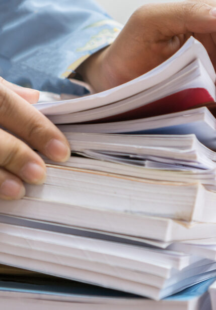 Businesswoman,Working,In,Stacks,Of,Paperwork,Files,For,Searching,Infomation